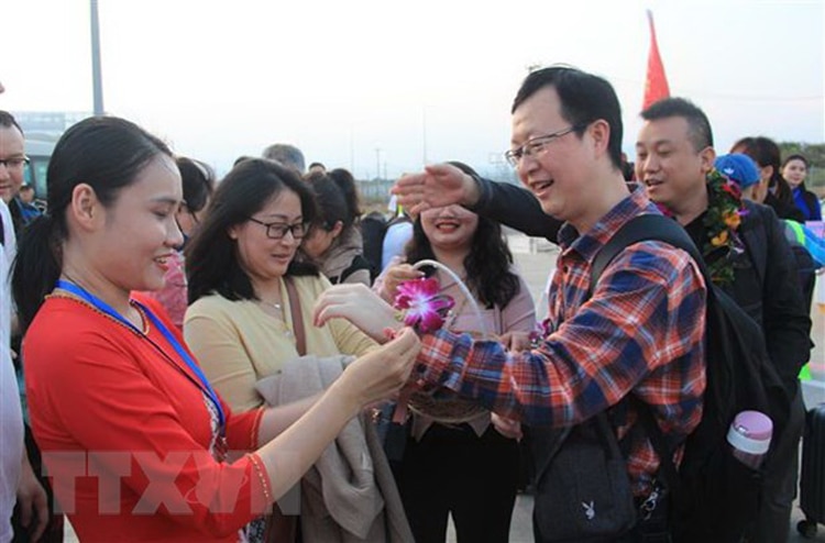 Đại diện các hãng lữ hành tại Khánh Hòa tặng hoa chào đón khách Macau, Trung Quốc. (Ảnh: TTXVN)