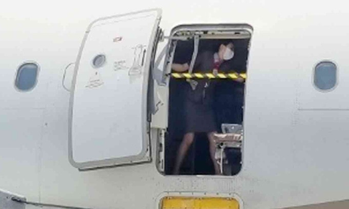 Nữ tiếp viên chắn ngang cửa thoát hiểm máy bay Asiana Airlines trong sự cố hôm 26/5. Ảnh: News1
