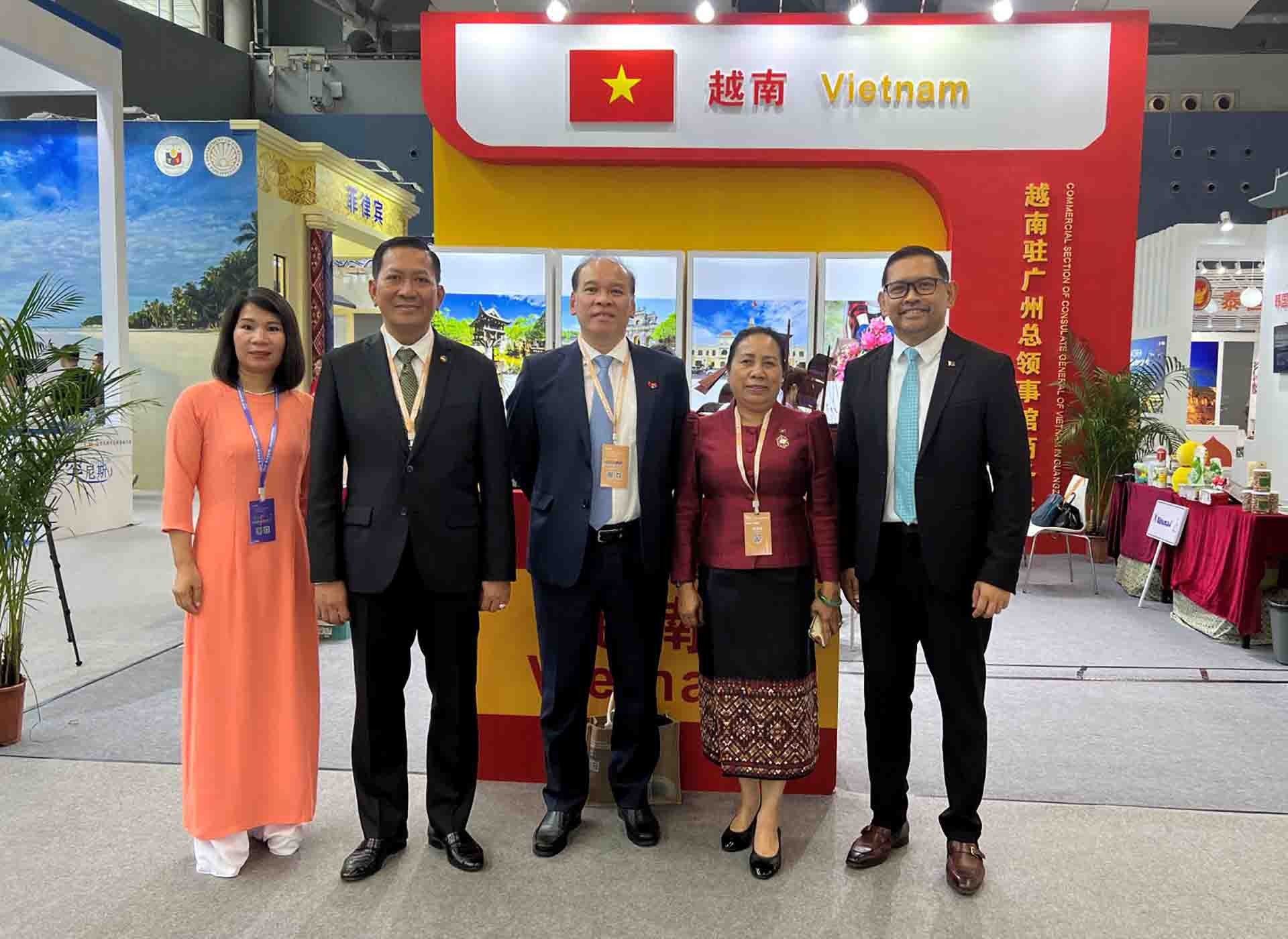 Tổng lãnh sự Vũ Việt Anh chụp ảnh lưu niệm cùng đoàn doanh nghiệp Việt Nam và khách đến thăm gian hàng Việt Nam.