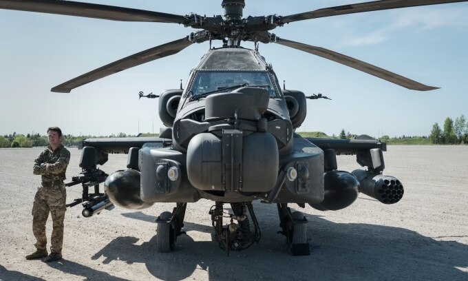 Một binh sĩ Anh đứng cạnh trực thăng Apache tại căn cứ quân sự Tapa ở Estonia. Ảnh: Washington Post