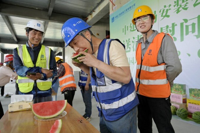 Nhân viên xây dựng ở Bắc Kinh ăn dưa hấu giải nhiệt ngày 16/6. Ảnh: Xinhua