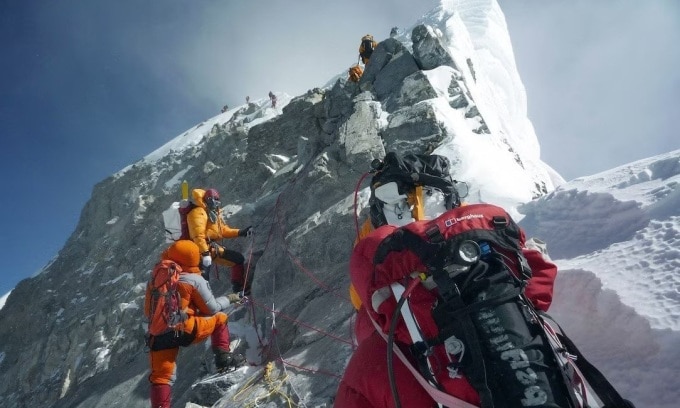 Những người leo núi đi bộ qua bậc thang Hillary khi phục đỉnh Everest.Ảnh: Pemba Dorje Sherpa