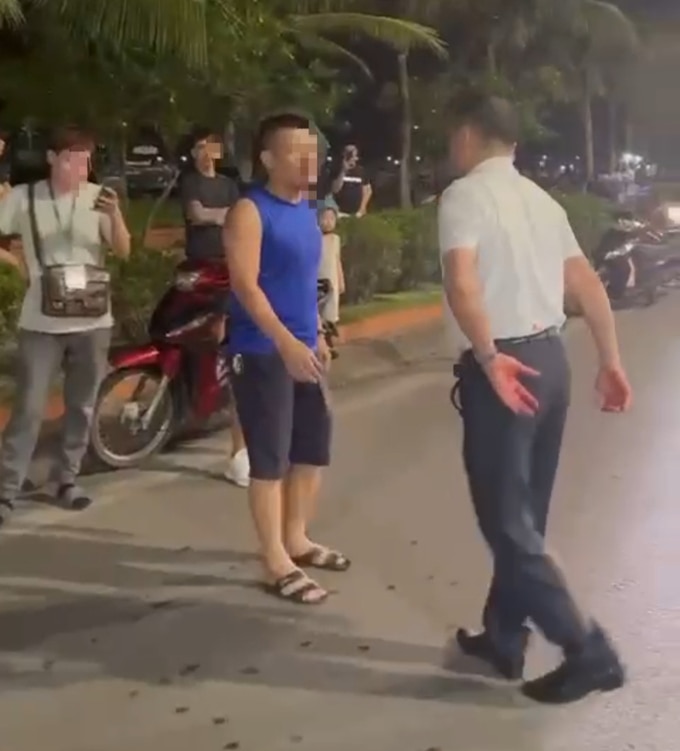 Người đàn ông mặc áo trắng có hành vi không chuẩn mực, được xác định là trung tá Nguyễn Thành Nam. Ảnh cắt từ clip.