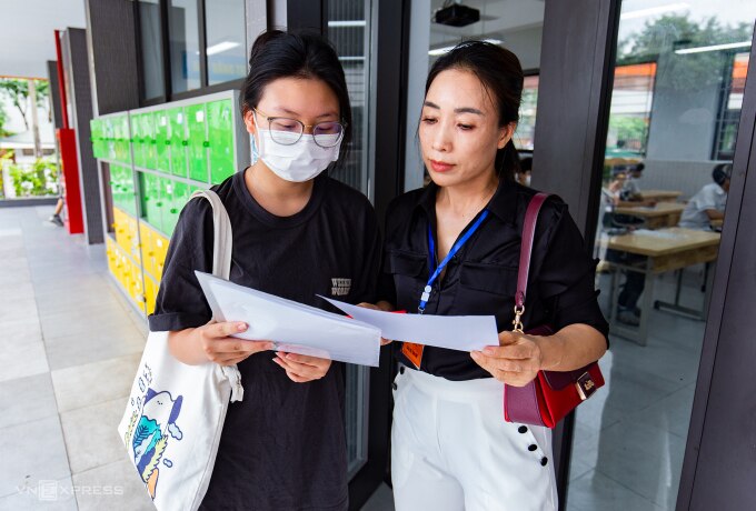 Thí sinh Hà Nội được giảm thị soát thông tin trên danh sách phòng thi với phiếu đăng ký dự thi lớp 10 trong buổi làm thủ tục, ngày 9/6. Ảnh: Tùng Đinh
