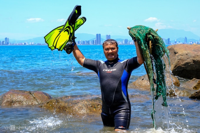 Anh Đào Đặng Công Trung, thành viên sáng lập nhóm lặn biển tự do ở Đà Nẵng với chiến lợi phẩm là rác thải vừa đưa lên từ biển. Ảnh: Nguyễn Đông