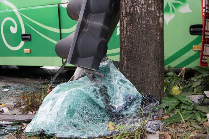 Đèn tín hiệu giao thông và kính ôtô vỡ nát nằm dưới gốc cây ven đường. Ảnh: Lam Sơn