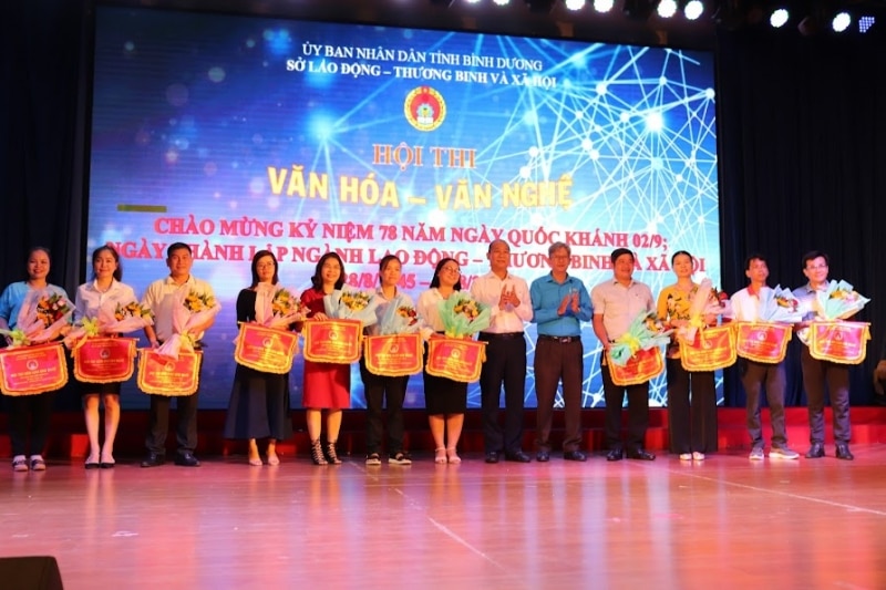 Ông Trịnh Tấn Tài (áo trắng) GĐ Sở LĐ-TB&XH trao cờ lưu niệm cho 11 đội tham gia hội thi.