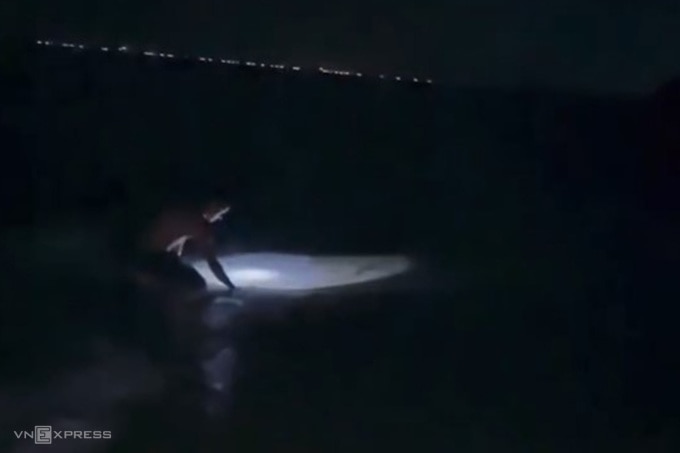 Anh Bách soi đèn bắt còng dọc bờ biển trong đêm. Ảnh: Võ Thạnh