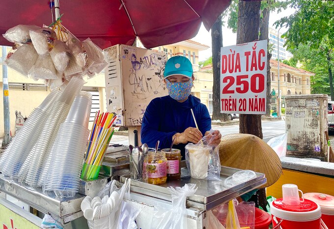Chị Nguyễn Thị Lệ Thuỷ, chủ xe dừa tắc đang chuẩn bị nước cho khách.