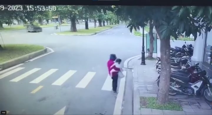 Hình ảnh cắt từ clip ghi lại khi đối tượng bế cháu bé tại trường học.