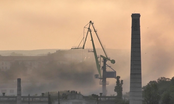 Khói bốc lên từ xưởng đóng tàu bị tên lửa Ukraine tấn công ở Sevastopol, Crimea, hôm 13/9. Ảnh: Reuters