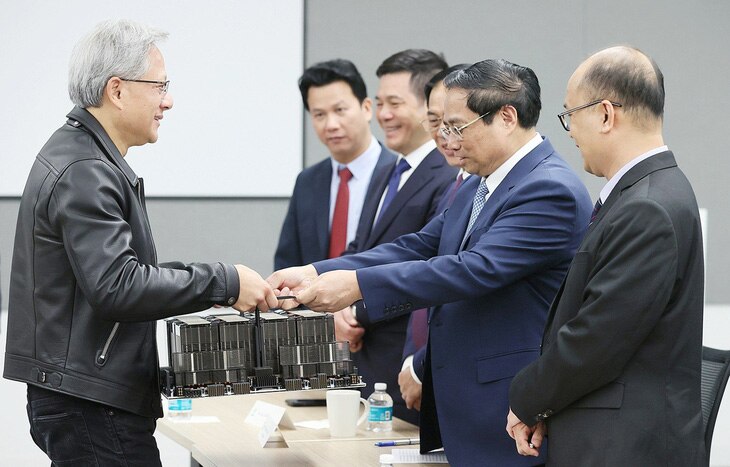 Chủ tịch Nvidia Jensen Huang giới thiệu với Thủ tướng Phạm Minh Chính con chip A100 dựa trên AI - Ảnh: DƯƠNG GIANG