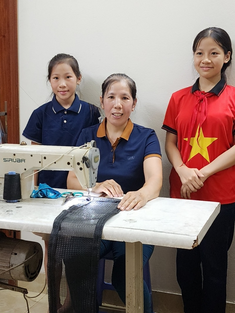 Ngoài giờ học, hai chị em Vương Thị Ngọc Lan và Vương Thị Thuỳ Linh cùng giúp mẹ may lưới, tăng thêm thu nhập