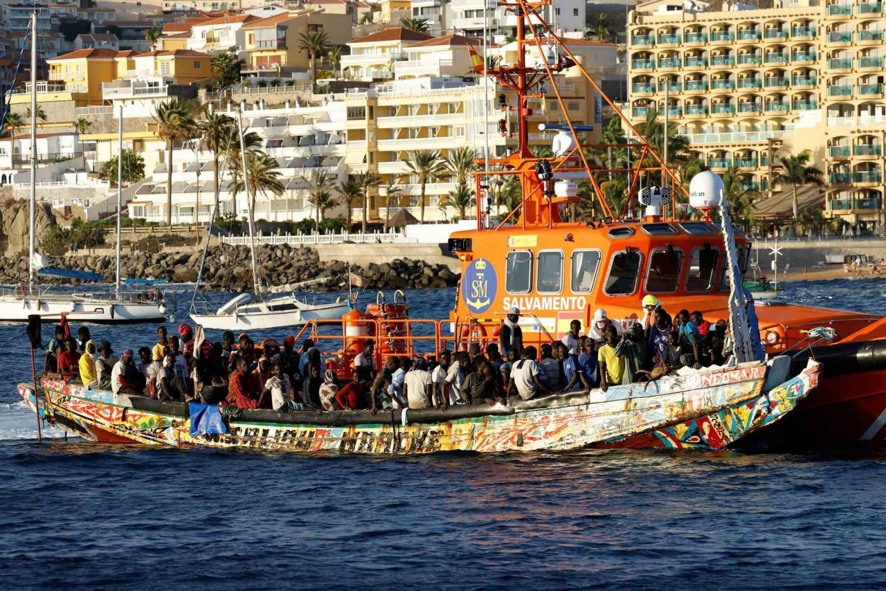 Một nhóm người di cư trên một chiếc thuyền gỗ được tàu bảo vệ bờ biển Tây Ban Nha kéo đến cảng Arguineguin, trên đảo Gran Canaria, Tây Ban Nha, ngày 21/10/2023. (Nguồn: Reuters)