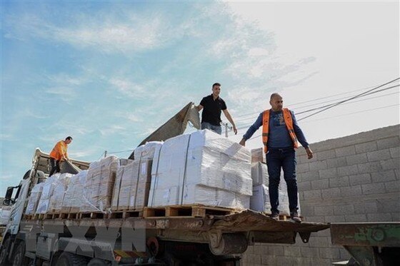 Công nhân bốc dỡ hàng cứu trợ gửi đến Dải Gaza qua cửa khẩu Rafah ngày 21-10-2023. Ảnh: TTXVN ảnh 3