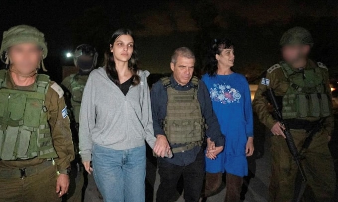 Hai con tin Judith Tai Raanan và Natalie Shoshana Raanan được tướng Israel Gal Hirsch (giữa) nắm tay dẫn đi hôm 20/10. Ảnh: Reuters