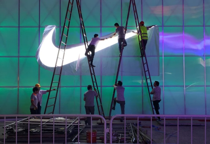 Công nhân lắp đèn logo Nike bên ngoài Nhà thi đấu Wukesong ở Bắc Kinh, Trung Quốc ngày 28/8/2019. Ảnh: Reuters