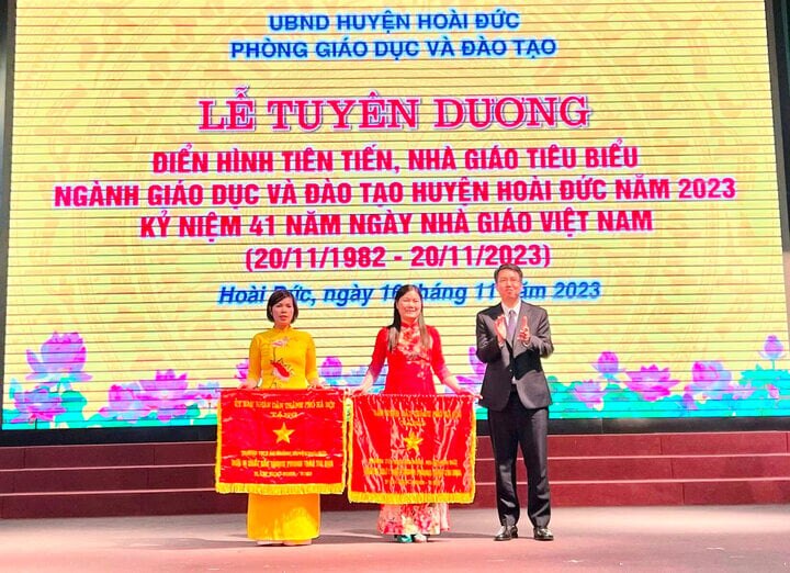 Ông Nguyễn Hoàng Trường, Chủ tịch UBND huyện Hoài Đức trao Cờ đơn vị thi đua xuất sắc của UBND thành phố cho các tập thể. (Ảnh: Ánh Dương)
