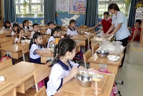 Một số học sinh trường Tiểu học Phú Hữu mang theo cơm, được giáo viên theo dõi, hỗ trợ ăn uống, ngày 27/10. Ảnh: NQ
