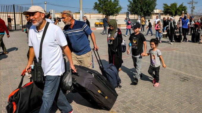 Những người vui mừng qua cửa khẩu Rafah sau khi được phép rời Dải Gaza ngày 1/11. Ảnh: AFP