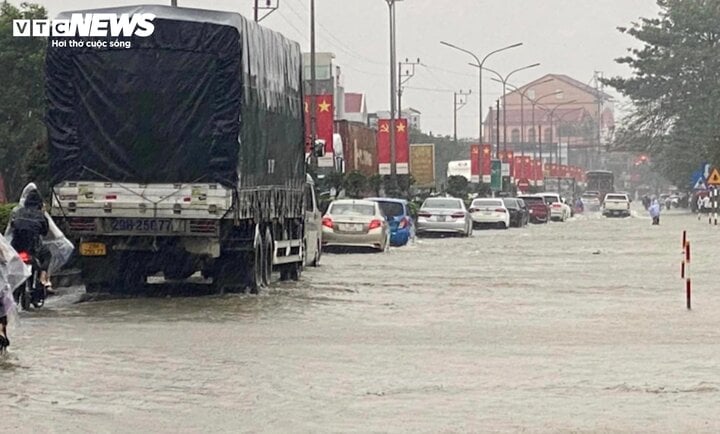 Mưa lớn khiến Quốc lộ 1A đoạn qua thị trấn Nghèn (huyện Can Lộc, tỉnh Hà Tĩnh) ngập sâu trong nước khiến các phương tiện lưu thông khó khăn. (Ảnh: V.N)