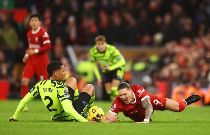 Tiền đạo Liverpool Nunez (số 9) ngã sau một pha tranh chấp với trung vệ Arsenal Saliba trong trận hòa  1-1 trên sân Anfield ở vòng 18 Ngoại hạng Anh ngày 23/12. Ảnh: Reuters