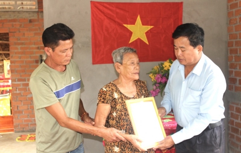 Đại diện lãnh đạo UBND xã Phước Ngãi trao quyết định bàn giao nhà đại đoàn kết cho hộ bà Trần Thị Đường.