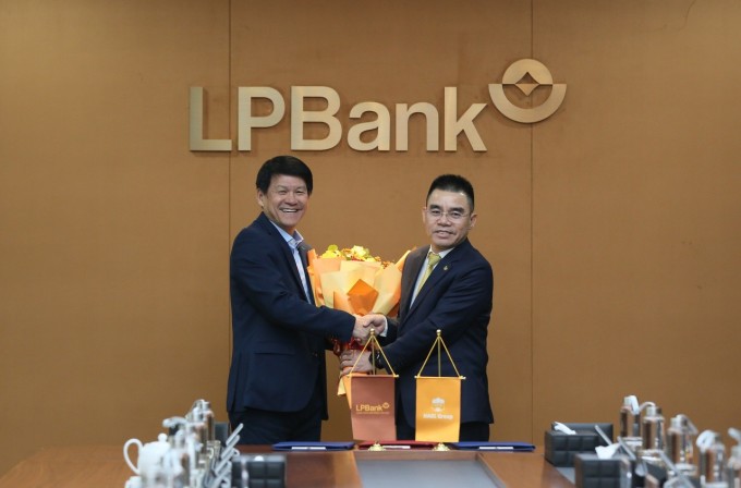 Ông Hồ Nam Tiến (phải), đại diện đơn vị tài trợ tặng hoa chúc mừng tân huấn luyện viên trưởng Vũ Tiến Thành. Ảnh: LPBank HAGL