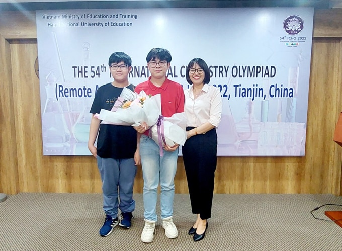 Minh Tuấn (giữa) cùng mẹ và em trai nhận hoa chúc mừng trong lễ công bố kết quả cuộc thi Olympic Hóa học quốc tế chiều 18/7/2022. Ảnh: Bình Minh