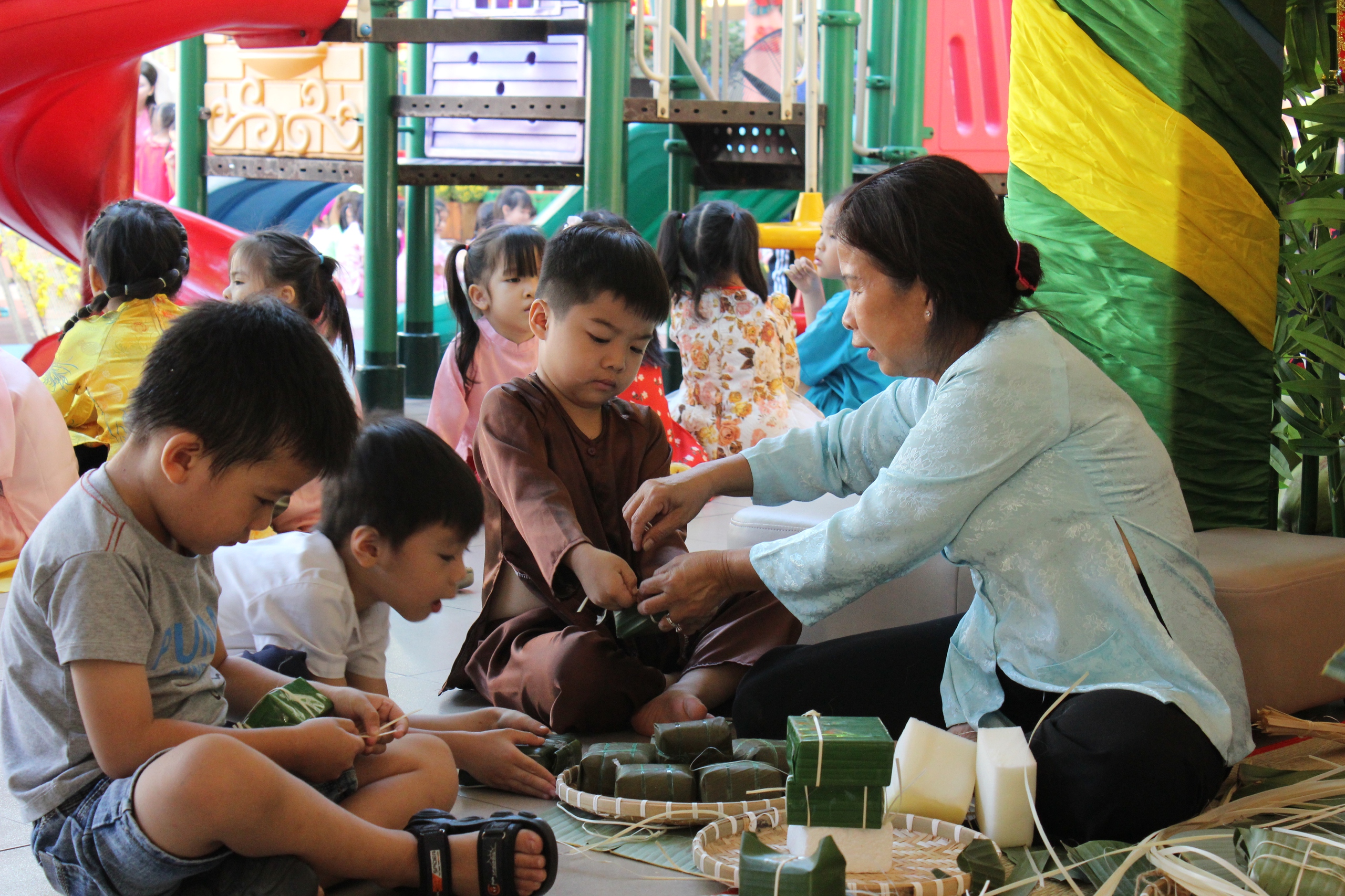 Trẻ mầm non TP.HCM khắc dưa hấu, gói bánh chưng đón tết sớm- Ảnh 4. Trẻ mầm non TP.HCM khắc dưa hấu, gói bánh chưng đón tết sớm- Ảnh 4.
