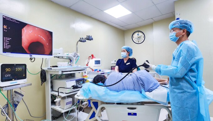Bác sĩ Hữu Tùng (áo xanh dương) nội soi dạ dày cho một bệnh nhân hồi tháng 10. Ảnh minh họa: Bệnh viện cung cấp
