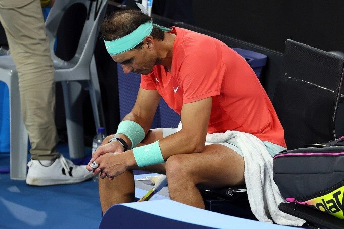 Nadal ngồi chờ chăm sóc y tế ở trận thua Thompson trên sân Pat Rafter Arena, Brisbane, Australia hôm 5/1. Ảnh: AFP