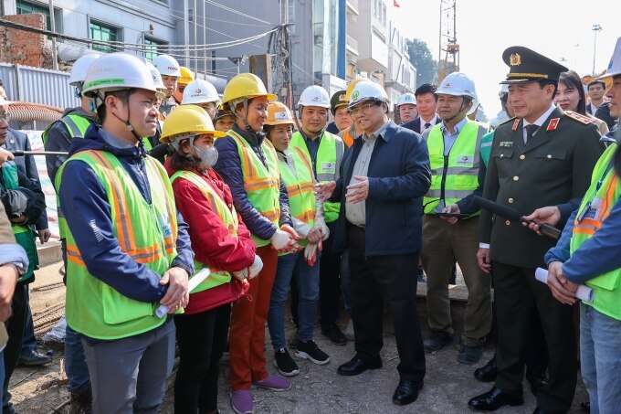 Thủ tướng trò chuyện, động viên cán bộ, công nhân đang làm việc trên công trường dự án đường sắt Nhổn - ga Hà Nội, sáng 12/2. Ảnh: Nhật Bắc