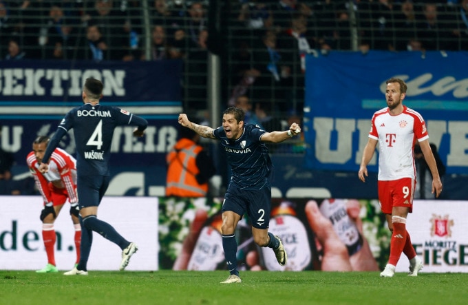 Tiền đạo Harry Kane thất vọng trước sự phấn khích của cầu thủ Bochum Cristian Gamboa khi kết thúc trận Bayern thua ngược 2-3 ở vòng 22 Bundesliga ngày 18/2. Ảnh: Reuters