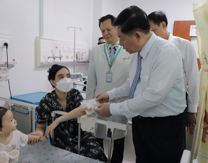 Trưởng Ban Tuyên giáo Trung ương mong thầy thuốc khơi dậy mạnh mẽ y đức, ý chí tự lực, tự cường- Ảnh 3. Ông Nguyễn Trọng Nghĩa thăm hỏi và tặng quà động viên cho gia đình bệnh nhi đang điều trị tại bệnh viện - Ảnh: CẨM NƯƠNG