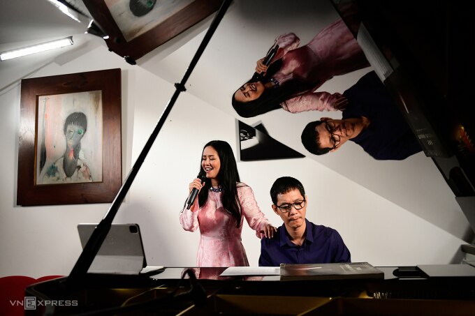 Hồng Nhung hát bên nhạc sĩ Hoài Sa tại tư gia, trong căn phòng có treo bức tranh Trịnh Công Sơn vẽ tặng chị. Ảnh: Thanh Tùng