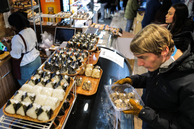 Thực khách Mỹ lựa mua cơm nắm onigiri tại New York, tháng 12/2023. Ảnh: AFP