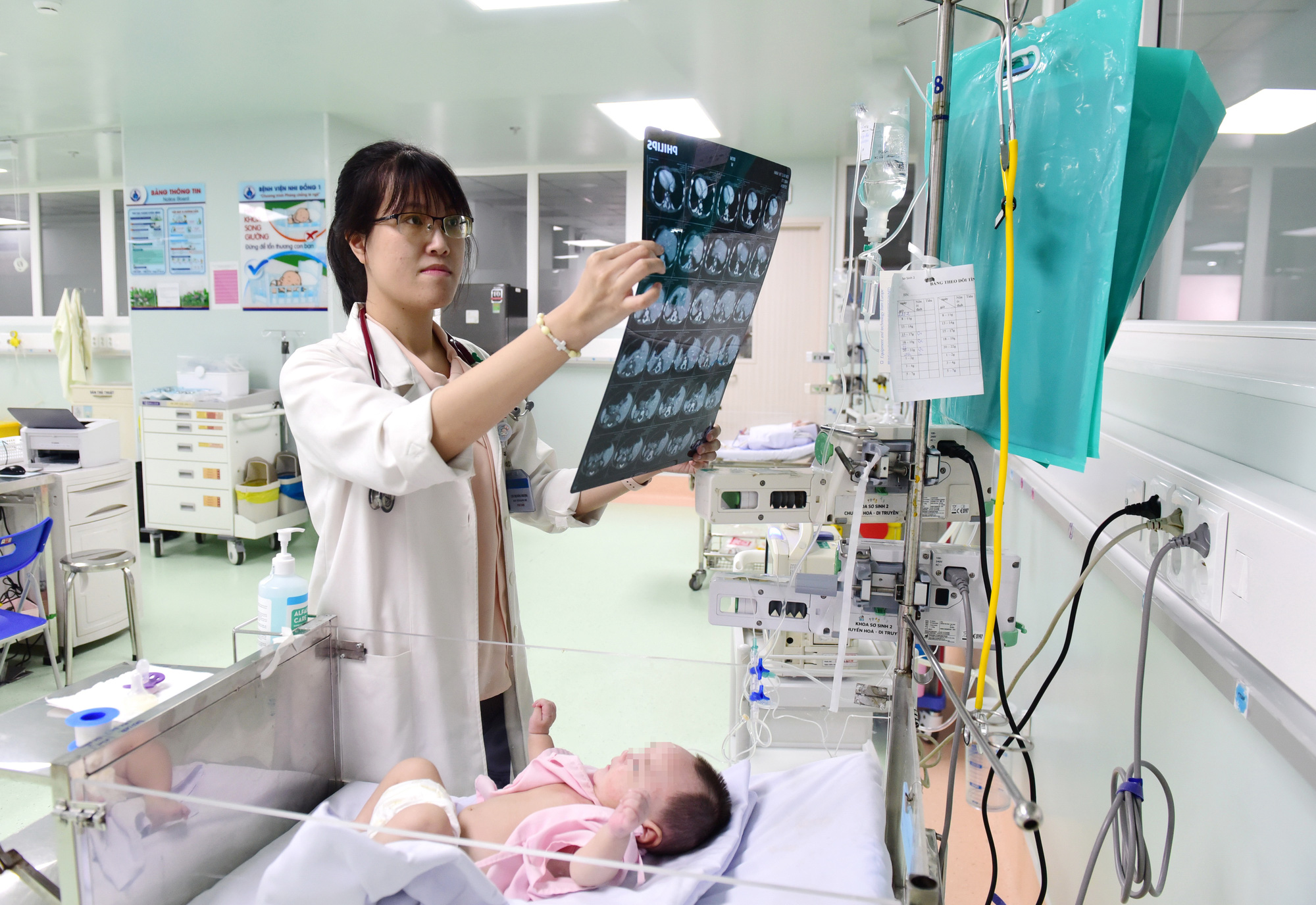 Đầu tư đặc biệt cho nghề y- Ảnh 1. Bác sĩ Chu Thị Hồng Phượng - 28 tuổi, trẻ nhất trong khoa sơ sinh 2 Bệnh viện Nhi đồng 1 - thăm khám cho bệnh nhi - Ảnh: D.PHAN
