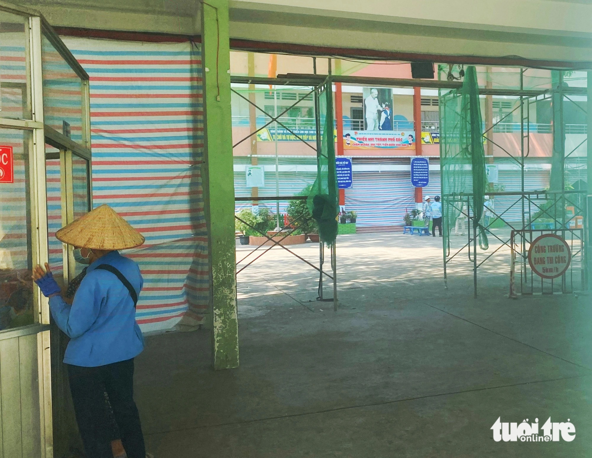 Bên trong Trường tiểu học Trần Văn Vân (TP Thủ Đức) rào lưới giàn giáo thi công, giăng bạt... - Ảnh: NGỌC PHƯỢNG