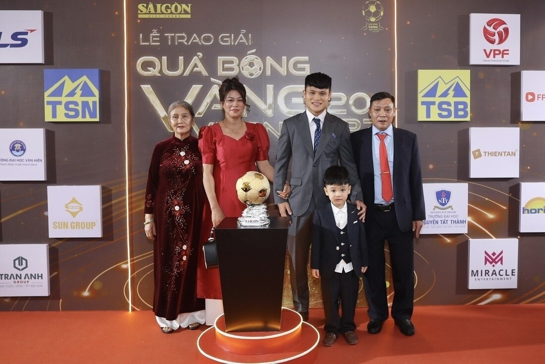 Trực tuyến trao giải Quả bóng vàng Việt Nam 2023 (20h): Tuấn Hải hay Hoàng Đức?- Ảnh 4. Gia đình tuyển thủ Phạm Tuấn Hải bên cạnh mô hình Quả bóng vàng - Ảnh: QUANG THỊNH