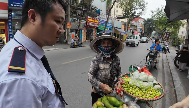 Xác minh vụ người bán hàng rong ở Hà Nội tính bán túi táo nhỏ giá 200.000 đồng cho khách Tây- Ảnh 2. Người bảo vệ xuất hiện giải vây cho hai du khách Tây - Ảnh cắt từ clip