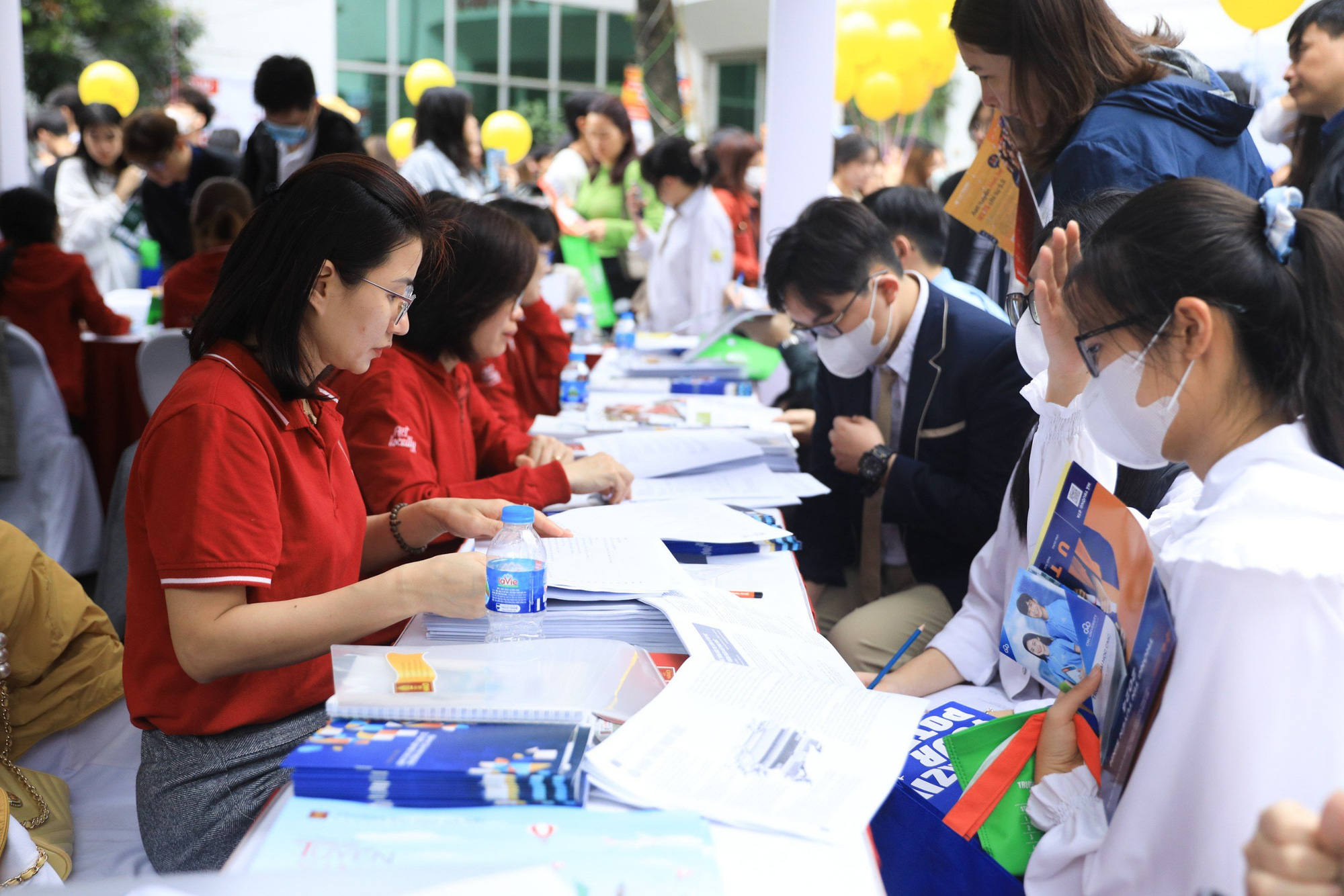 Nhiều thí sinh chọn sai ngành, sai trường, rất cần tư vấn tuyển sinh- Ảnh 9. Học sinh và phụ huynh tìm hiểu thông tin ngành nghề tại gian tư vấn của các trường - Ảnh: DANH KHANG