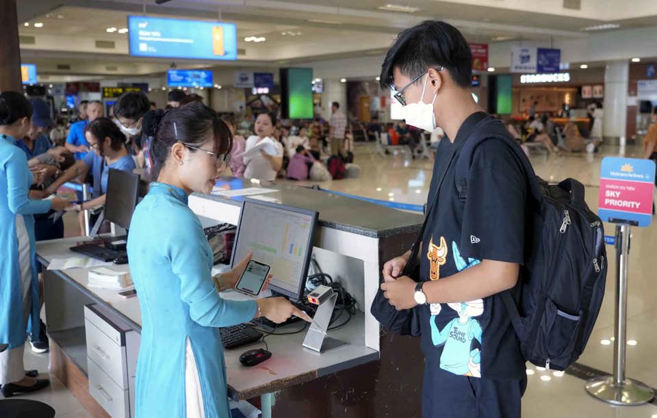 Nhân viên hàng không Vietnam Airlines làm thủ tục xuất vé cho khách hàng tại sân bay Nội Bài. Ảnh: Hoài Nam