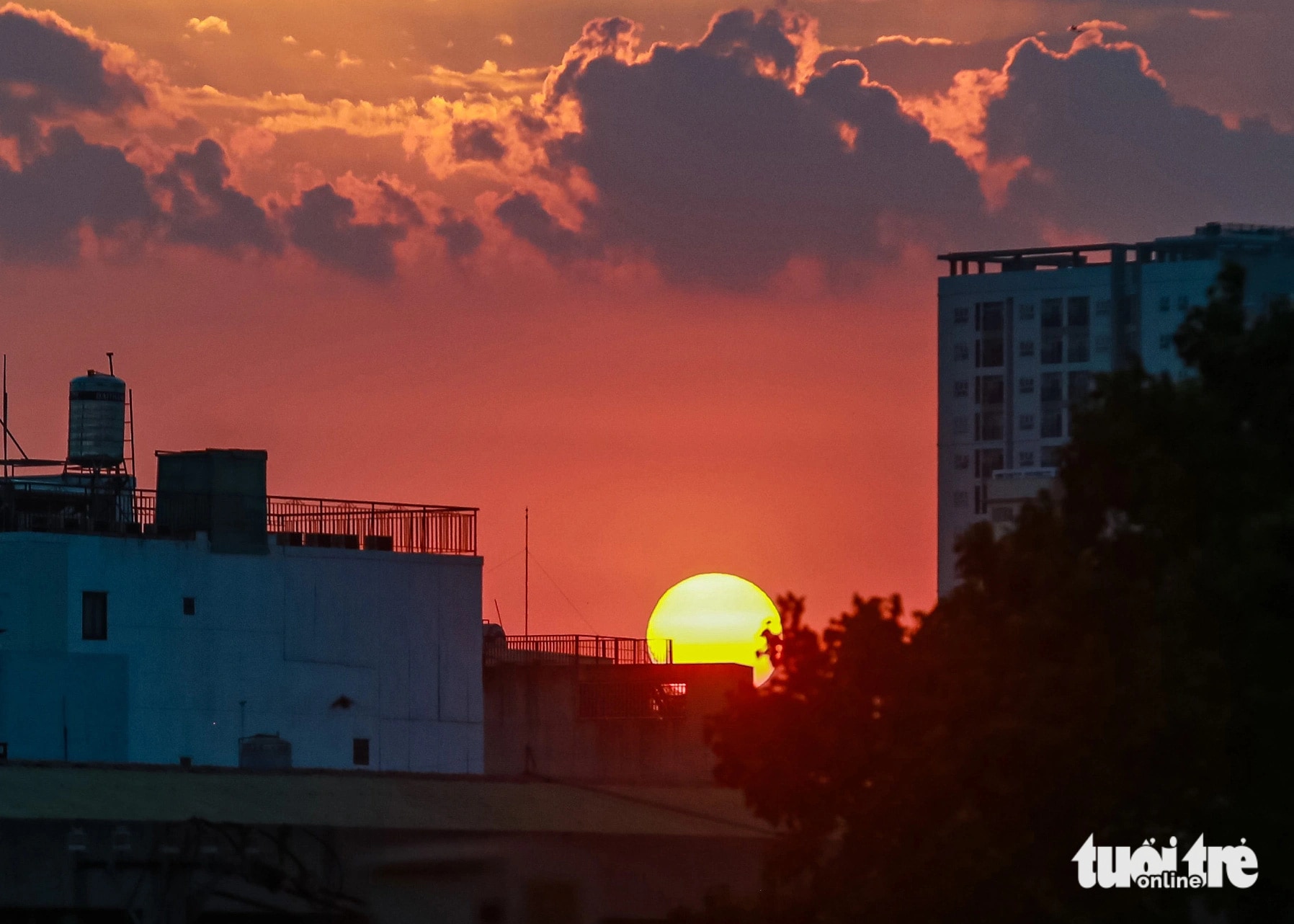Sau đó ít phút, Mặt trời chuyển sang màu đỏ như lòng đỏ trứng gà. Góc nhìn từ cầu Kinh (Thanh Đa) chiều 26-3 - Ảnh: CHÂU TUẤN