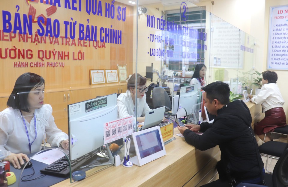 Công chức UBND phường Quỳnh Lôi, quận Hai Bà Trưng hướng dẫn người dân làm thủ tục hành chính. Ảnh: Linh Chi