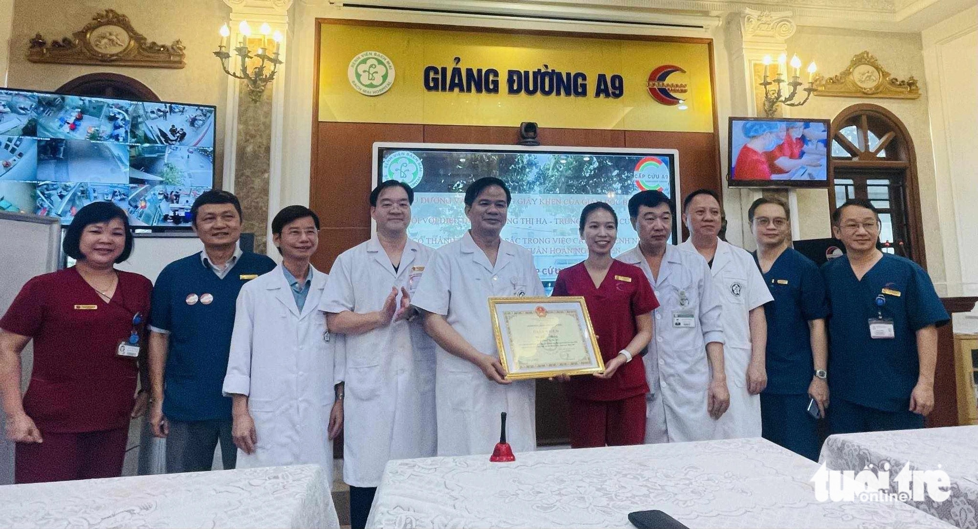 Lãnh đạo Bệnh viện Bạch Mai trao bằng khen cho điều dưỡng Hạ - Ảnh: T.B