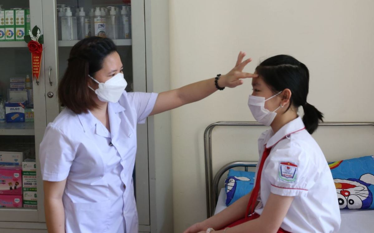 Nhân viên y tế học đường ở Hạ Long (Quảng Ninh) hướng dẫn kiểm tra sức khỏe cho học sinh - Ảnh: TRẦN THANH