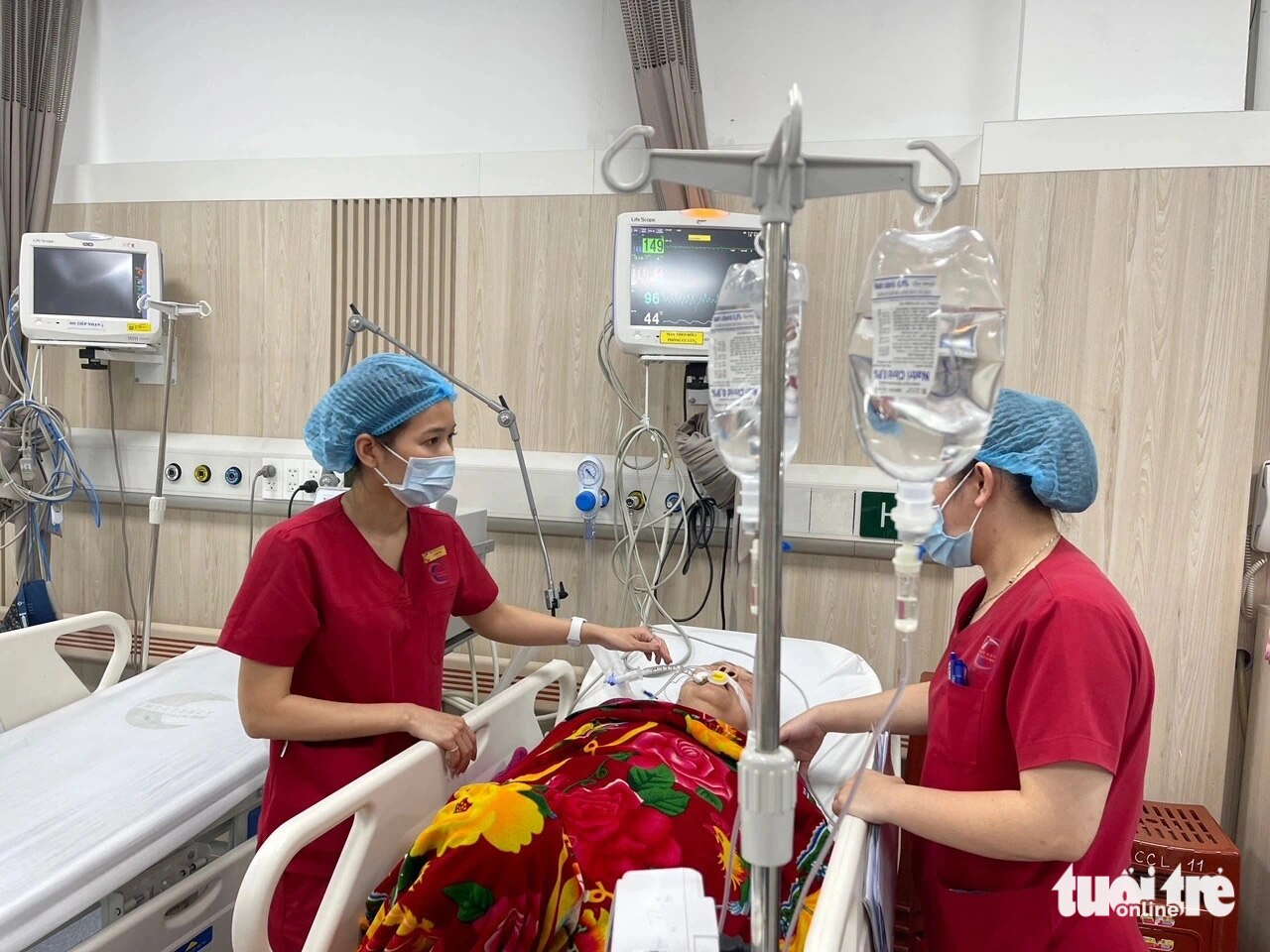Nữ điều dưỡng Đặng Thị Hạ (bìa trái) làm việc ở Bệnh viện Bạch Mai