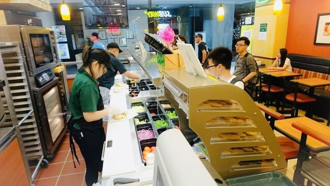 Học sinh Việt Nam làm thêm tại một tiệm bánh mì ở Singapore. Ảnh: Đinh Hoàng Hà