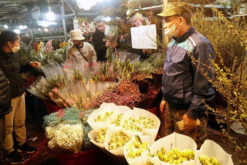 Người d&acirc;n mua hoa tại chợ hoa đ&ecirc;m Quảng An (T&acirc;y Hồ). Ảnh: Ho&agrave;i Nam